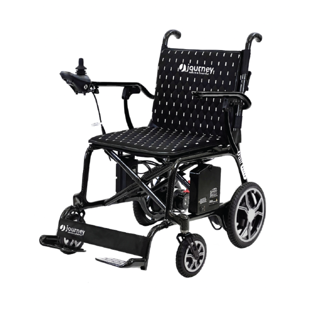 The Journey Air Elite Folding Carbon Fiber Powerchair, weighing only 29 lbs, boasts a travel-friendly black design with a joystick controller, cushioned seat, and Journey branding on the backrest. It features large rear wheels, small front wheels, and a footrest for comfortable mobility support.